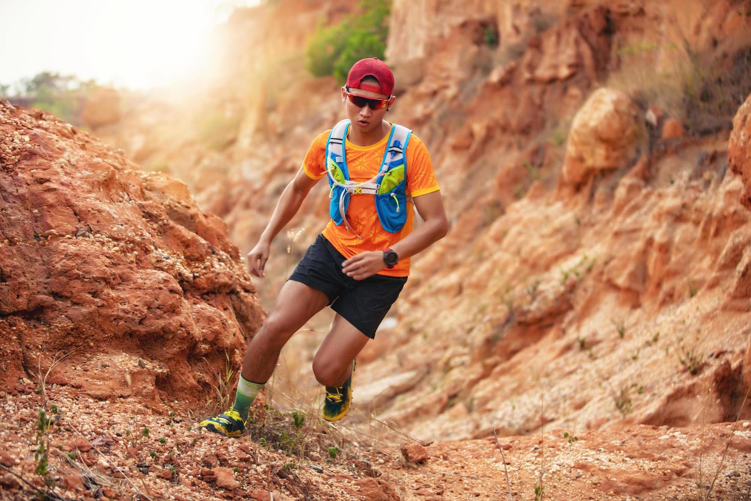 um homem corredor de trilha. e pés de atleta usando sapatos esportivos para trilha nas montanhas foto