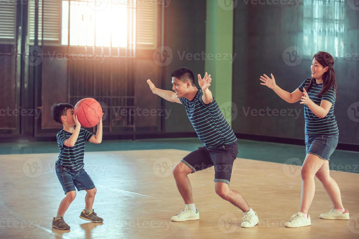 família asiática jogando basquete juntos. família feliz passando tempo livre junta nas férias foto