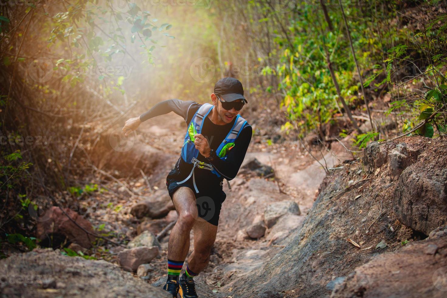 um homem corredor de trilha. e pés de atleta usando sapatos esportivos para trilha na floresta foto