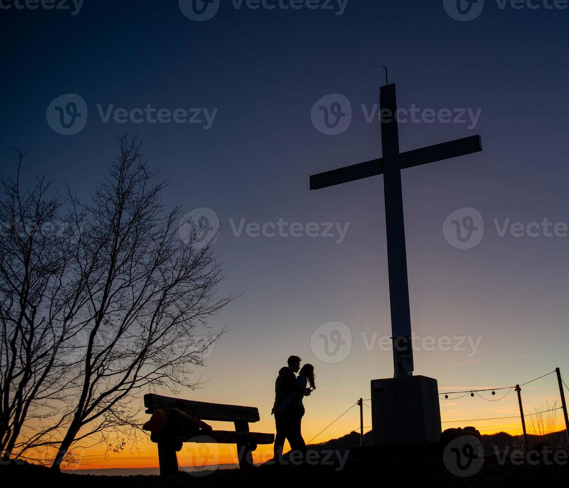 topo da montanha ao pôr do sol com namorados foto