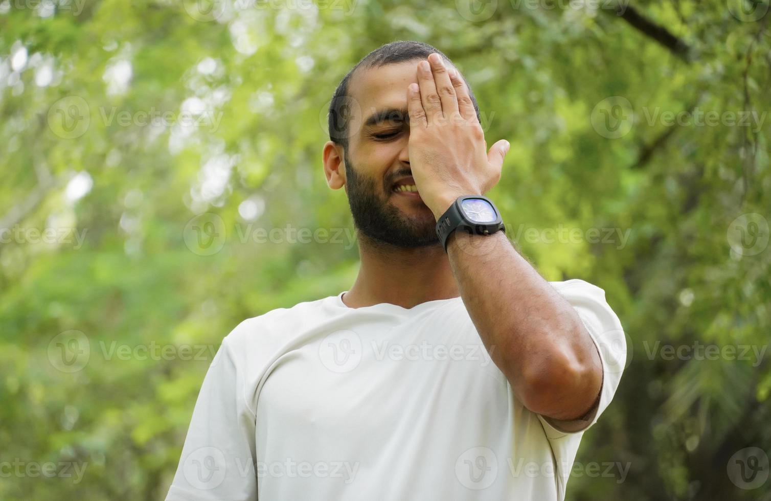 um homem se sente tímido e feliz cobre seu rosto foto