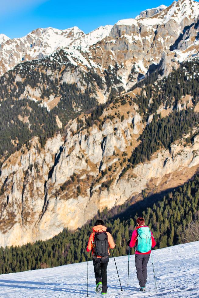 namoradas durante uma caminhada de inverno na neve nas montanhas foto