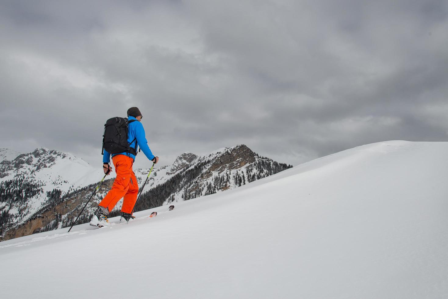 homem com escalada de alpinismo de esqui em direção ao cume foto