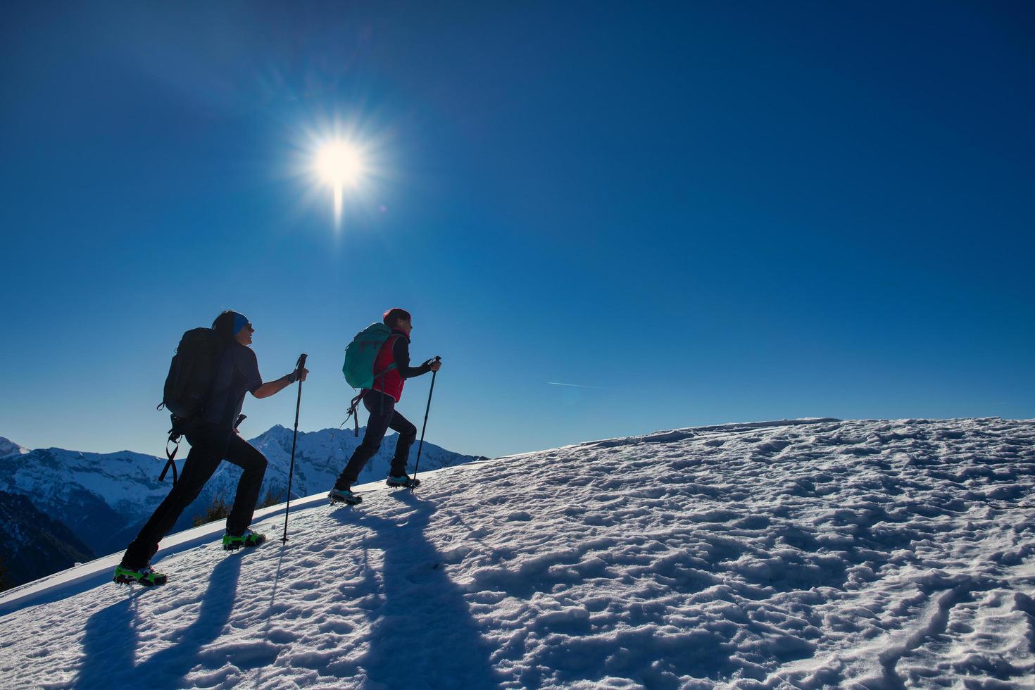 casal de amigas durante uma caminhada de neve nas montanhas foto