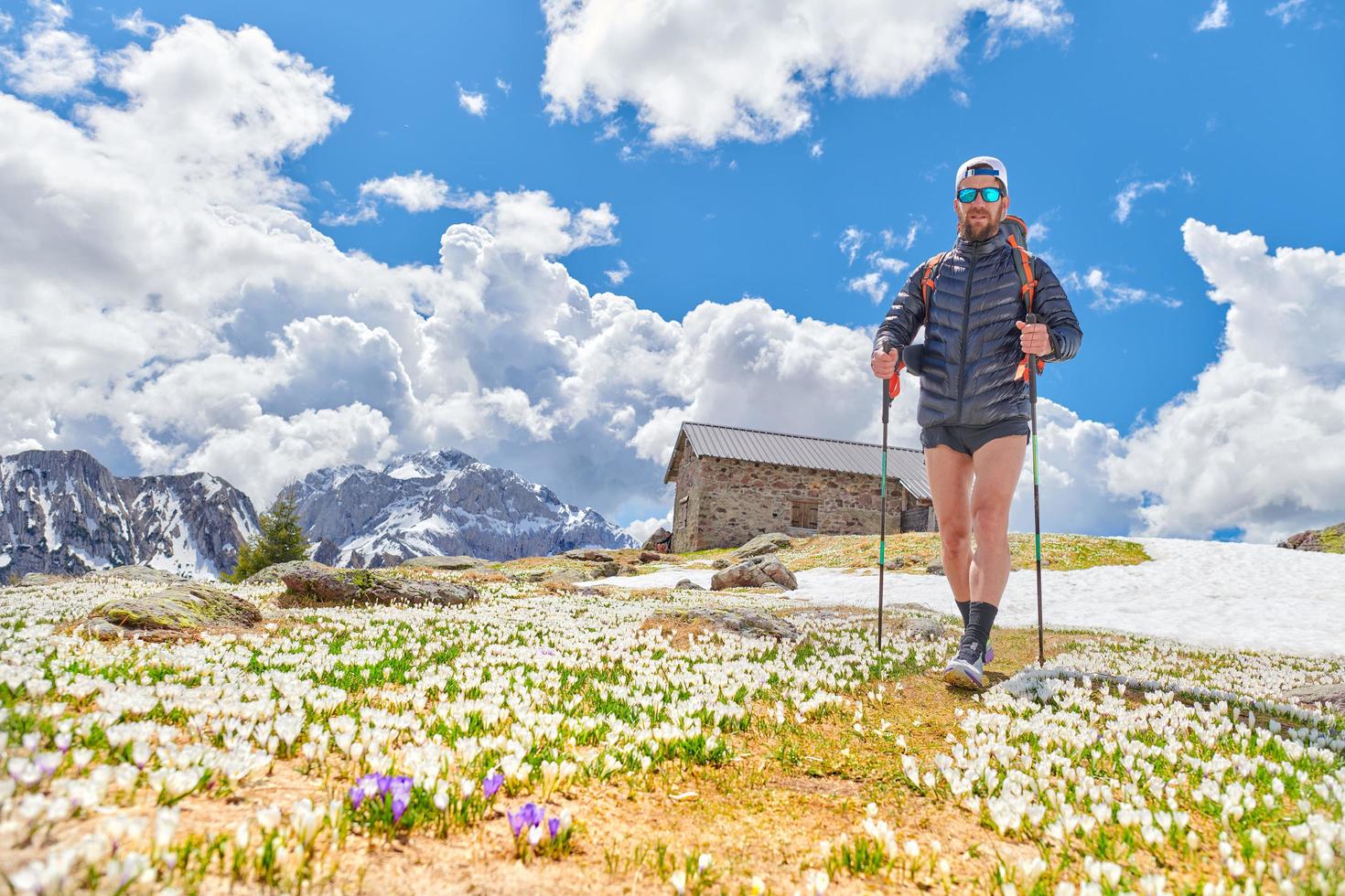 desportista com barba durante uma caminhada de primavera nas montanhas foto