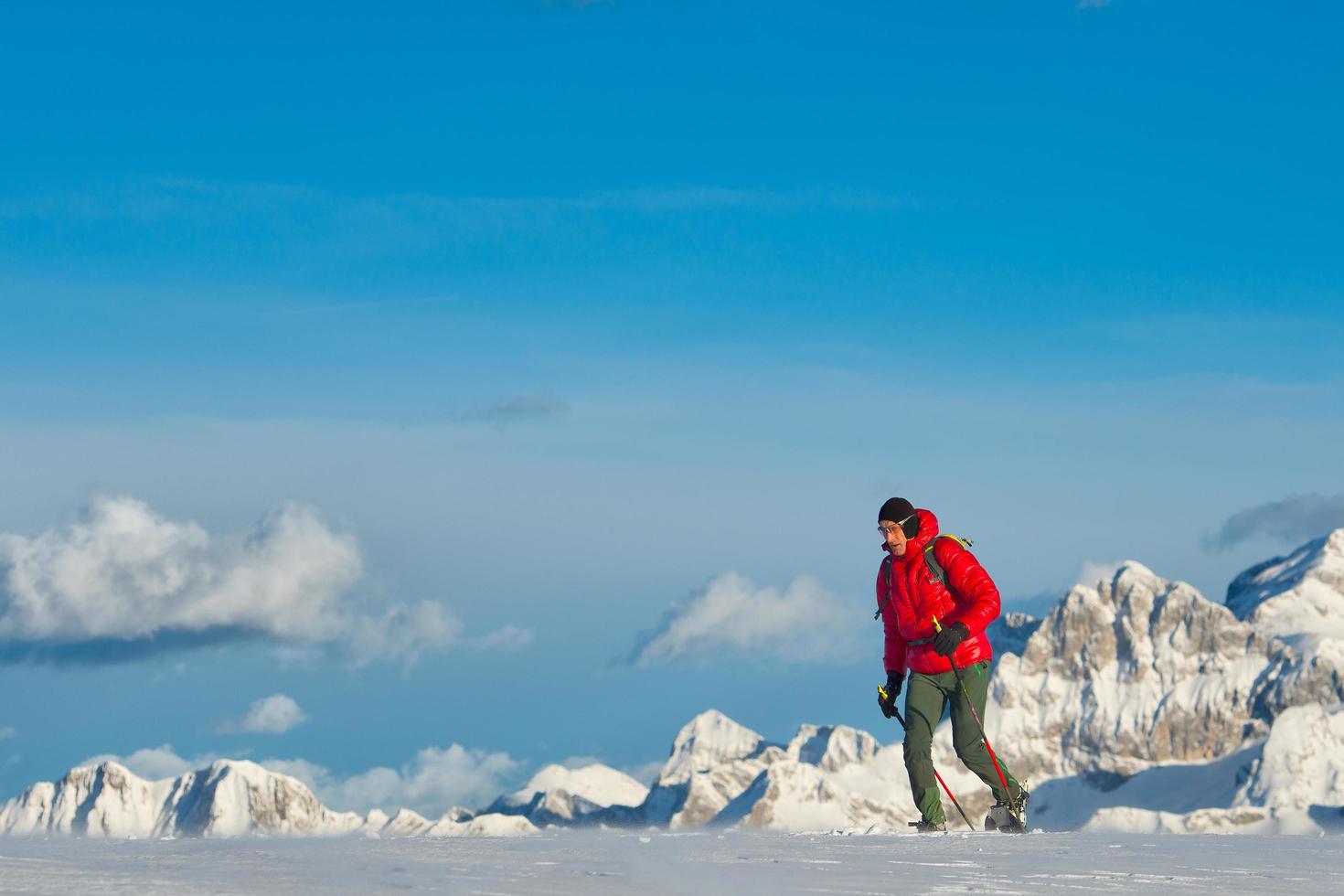 homem com raquetes de neve nas montanhas foto