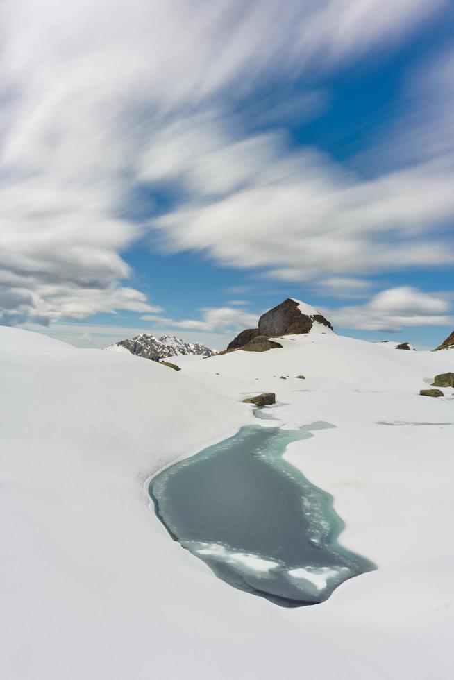 pequeno lago de montanha na neve ao degelo foto