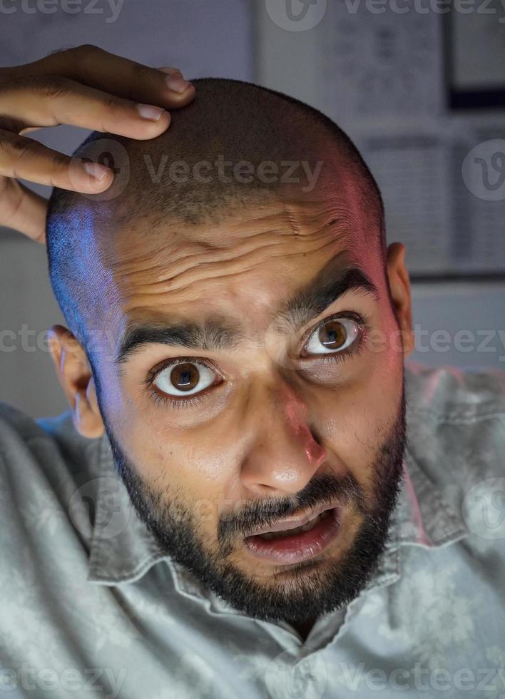 um jovem careca chocado na frente da câmera foto