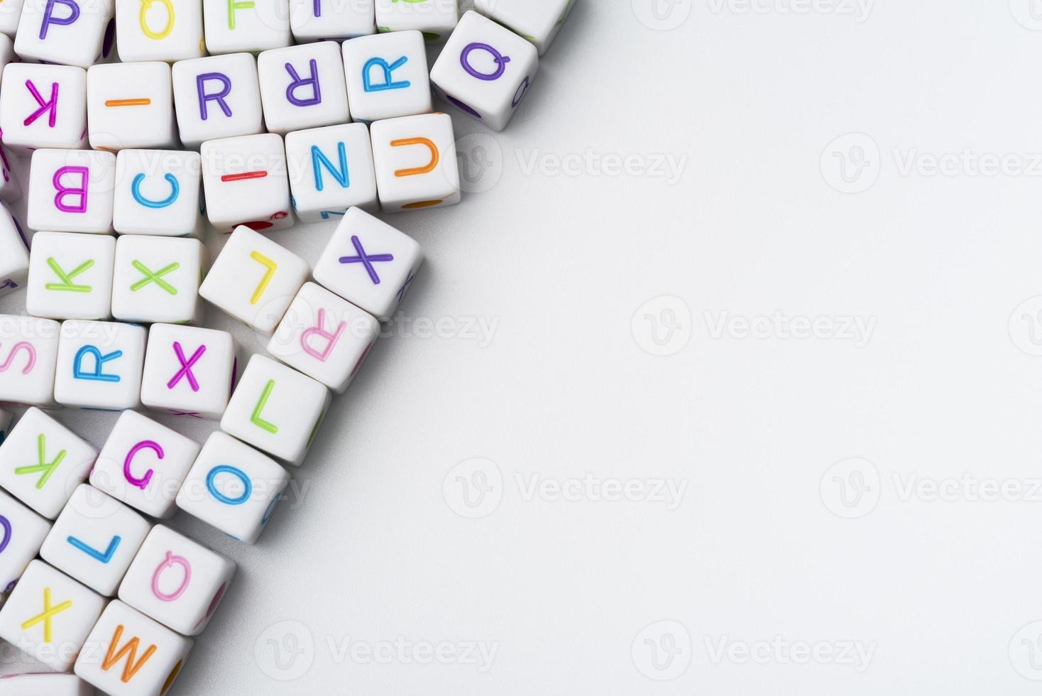 muitos cubos decorativos coloridos com letras em um fundo branco. foto