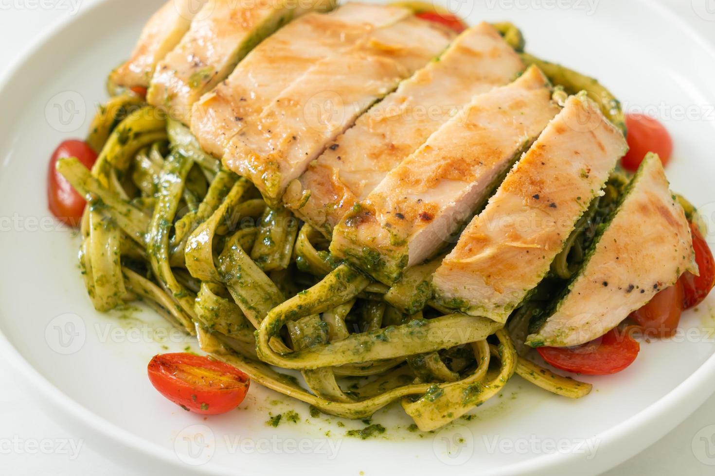 macarrão fettuccine espaguete ao molho pesto com frango grelhado foto