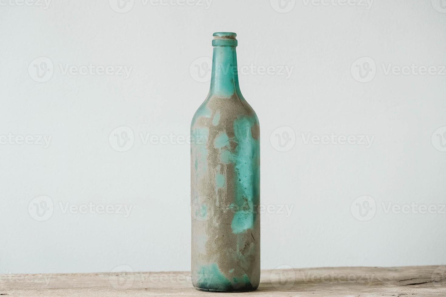 garrafa de vidro vazia na sujeira em uma mesa de madeira. copiar, espaço vazio para texto foto