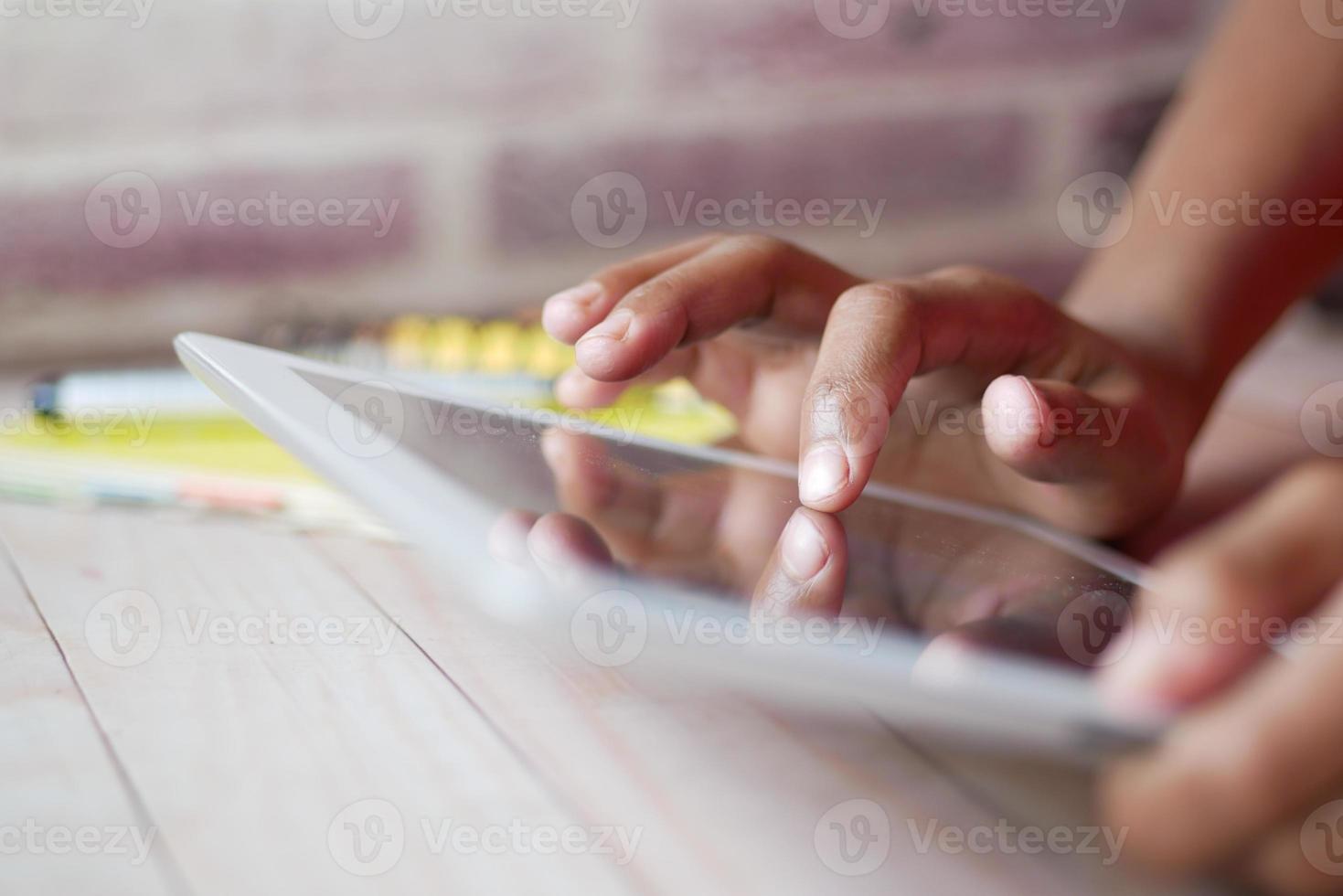 criança mão apontando o dedo na tela do tablet digital. foto