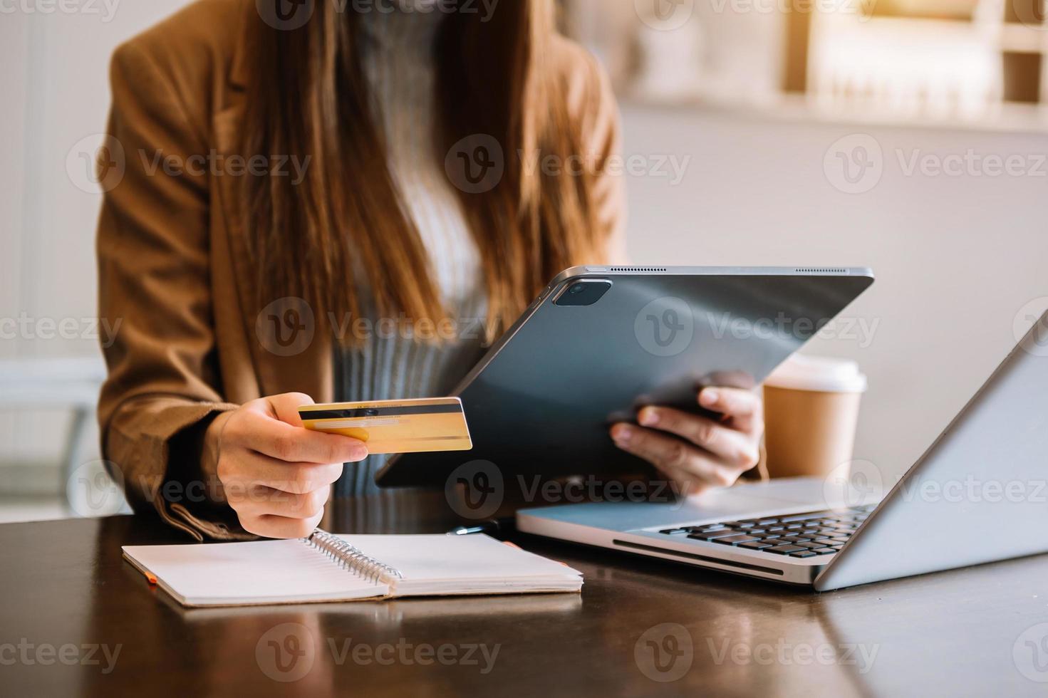 mãos de mulher usando smartphone e segurando cartão de crédito com camada digital como conceito de compras online foto