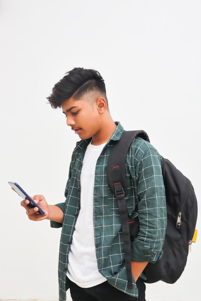 estudante universitário indiano usando smartphone em fundo branco. foto