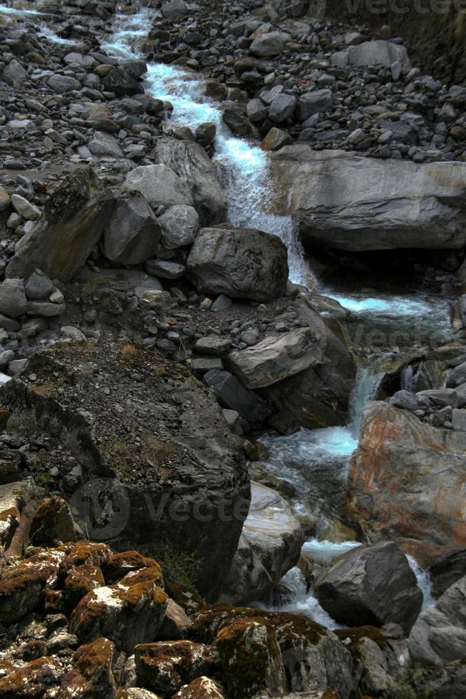 água descendo a colina através de terreno rochoso foto