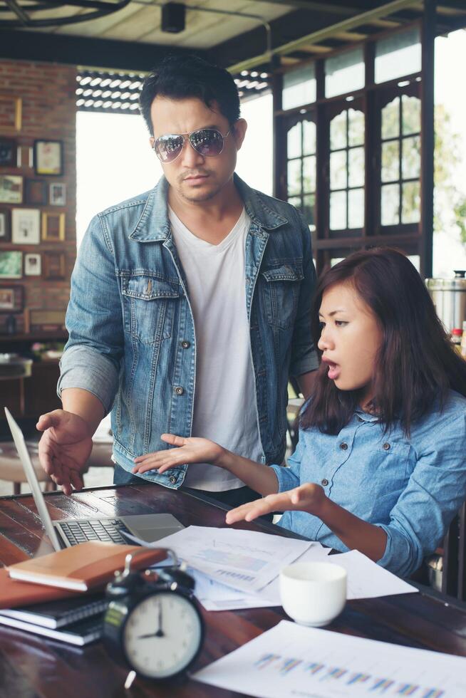 chefe gritando para um funcionário estressado quando ela trabalha com laptop no escritório, falando sobre não ser concluído pelo trabalho, conceito de falha de negócios. foto