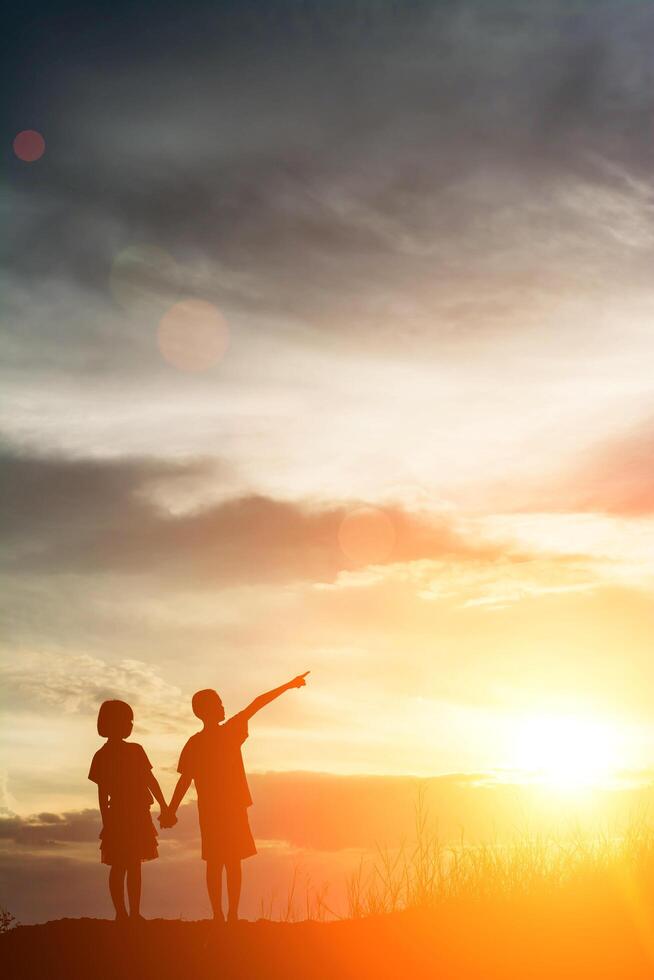 silhueta menino e menina apontando para o futuro. foto