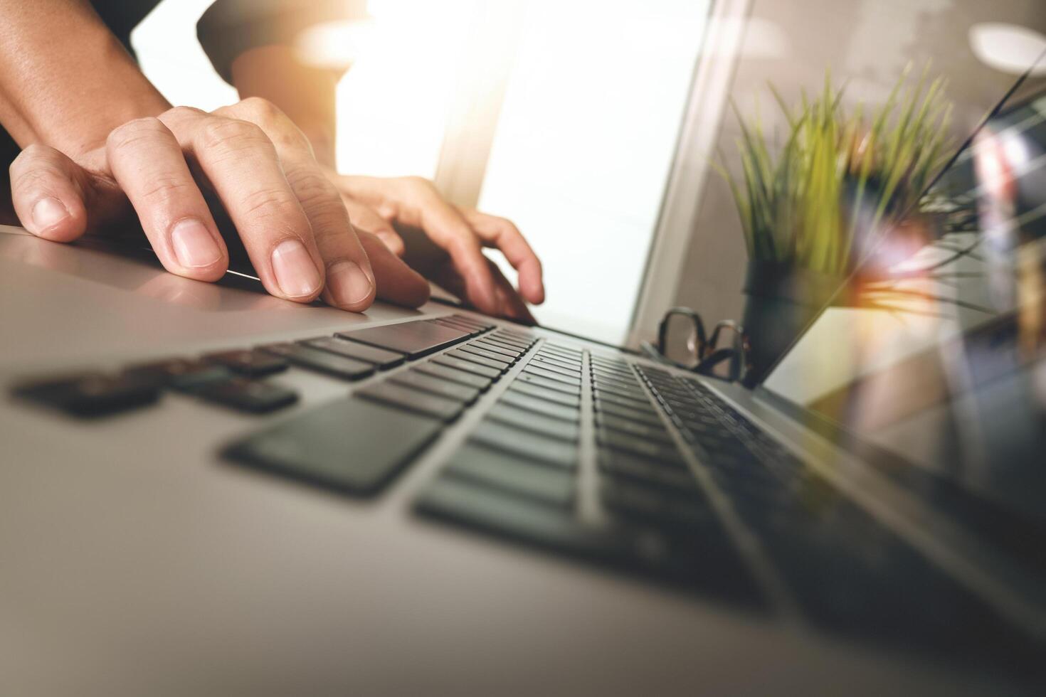 mão de homem de negócios trabalhando no computador portátil de tela em branco na mesa de madeira como conceito foto