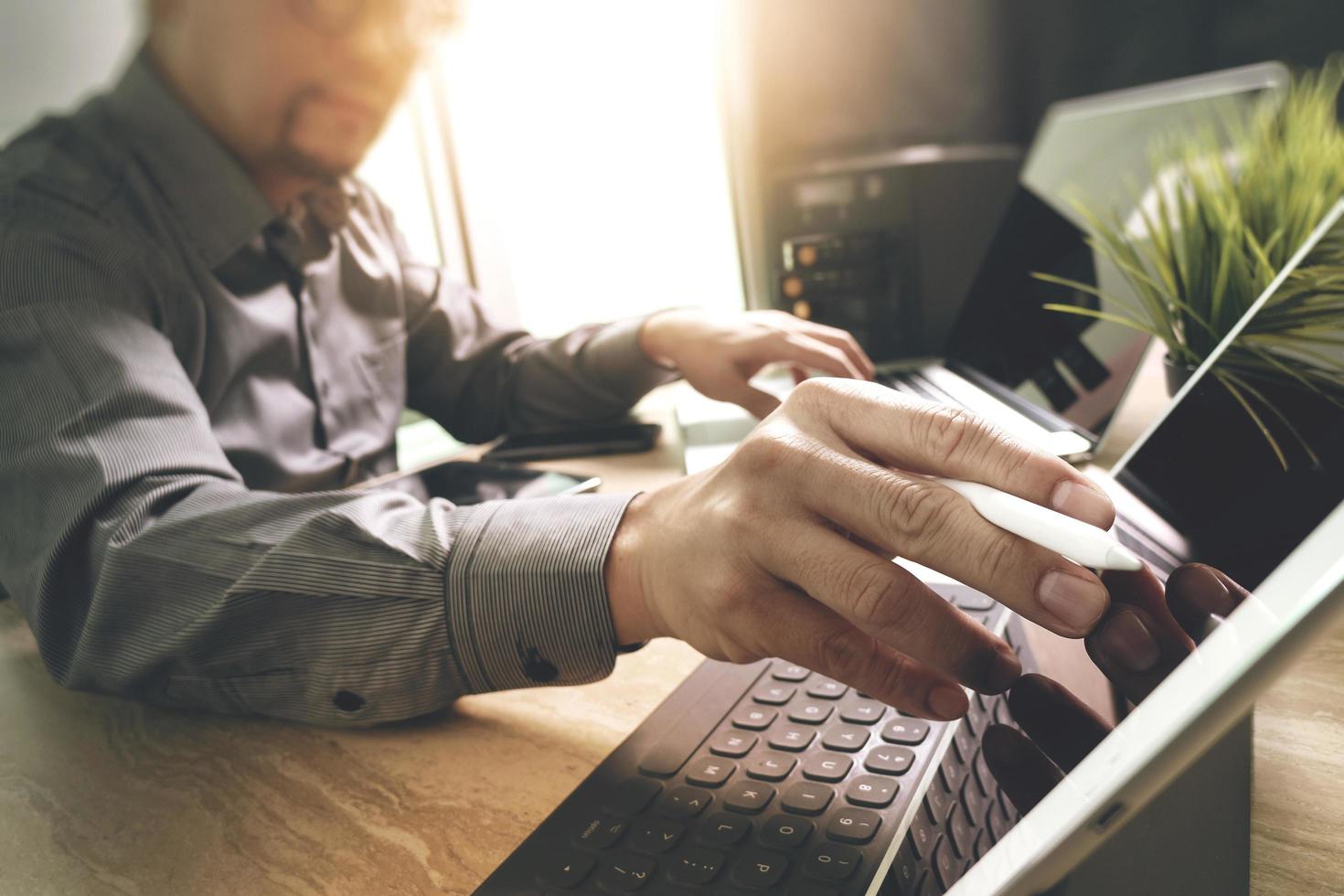 desenvolvedor terceirizado trabalhando em mesa de mármore trabalhando software de aplicativo móvel de computador portátil e teclado inteligente de doca de tablet digital, servidor compacto, efeito de reflexo solar foto