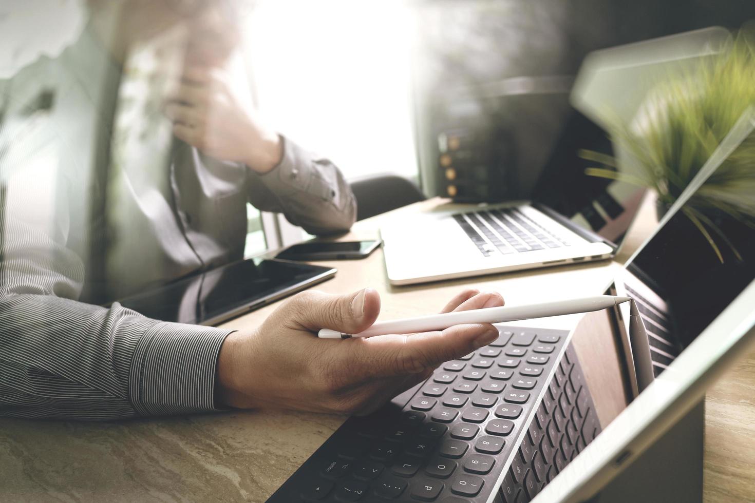 desenvolvedor terceirizado trabalhando em mesa de mármore trabalhando software de aplicativo móvel de computador portátil e teclado inteligente de doca de tablet digital, servidor compacto, efeito de reflexo solar foto