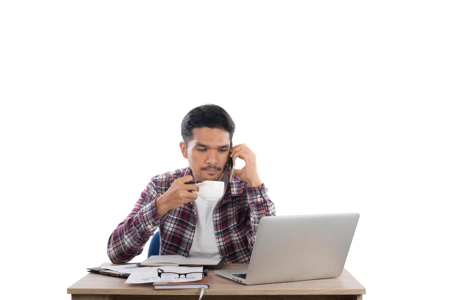 empresário falando ao telefone enquanto trabalha com laptop no escritório isolado no fundo branco. foto