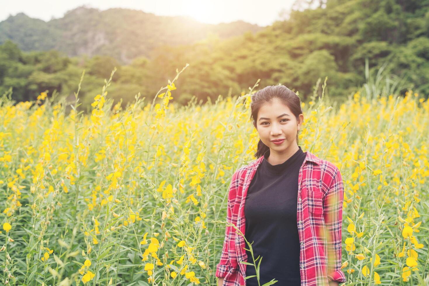 jovem e bela mulher de pé no gozo do campo de flores. foto