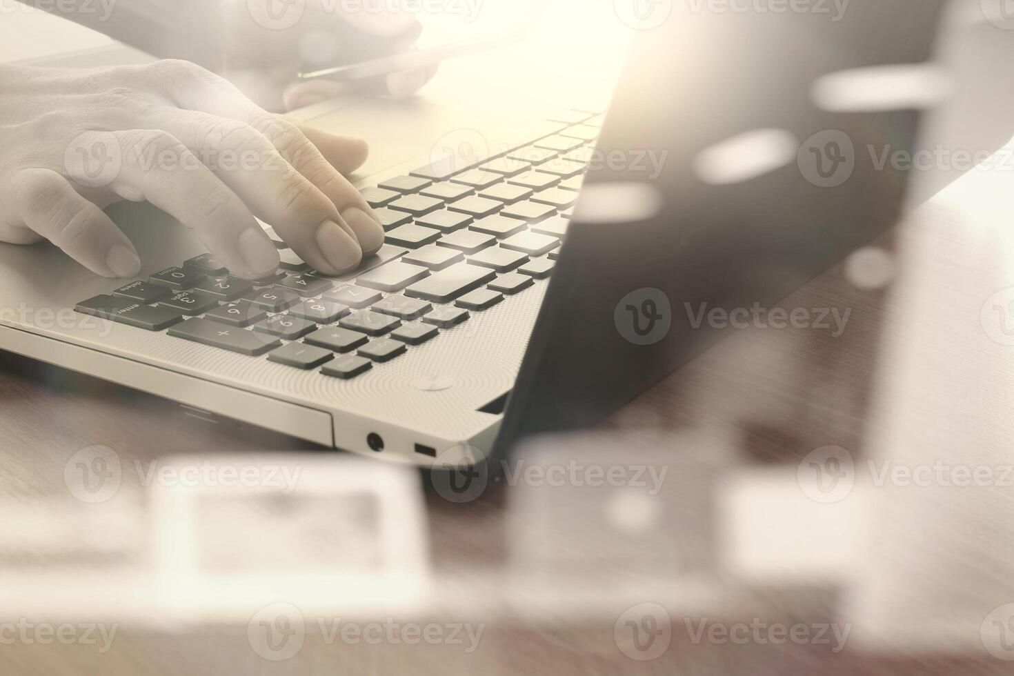 close-up da mão do homem de negócios trabalhando no computador portátil com diagrama de rede social na mesa de madeira como conceito foto