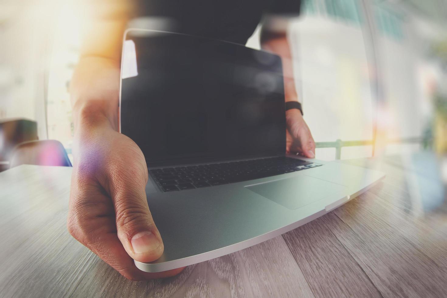 mão de designer trabalhando com computador portátil na mesa de madeira como conceito de web design responsivo foto