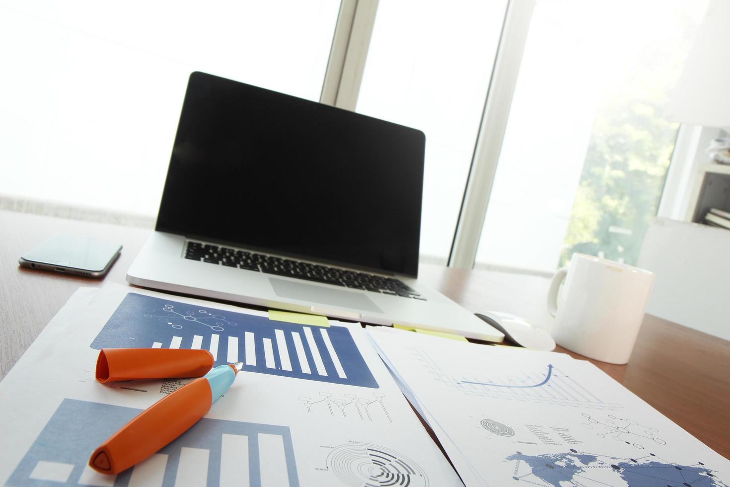 local de trabalho de escritório com laptop e telefone inteligente na mesa de madeira foto