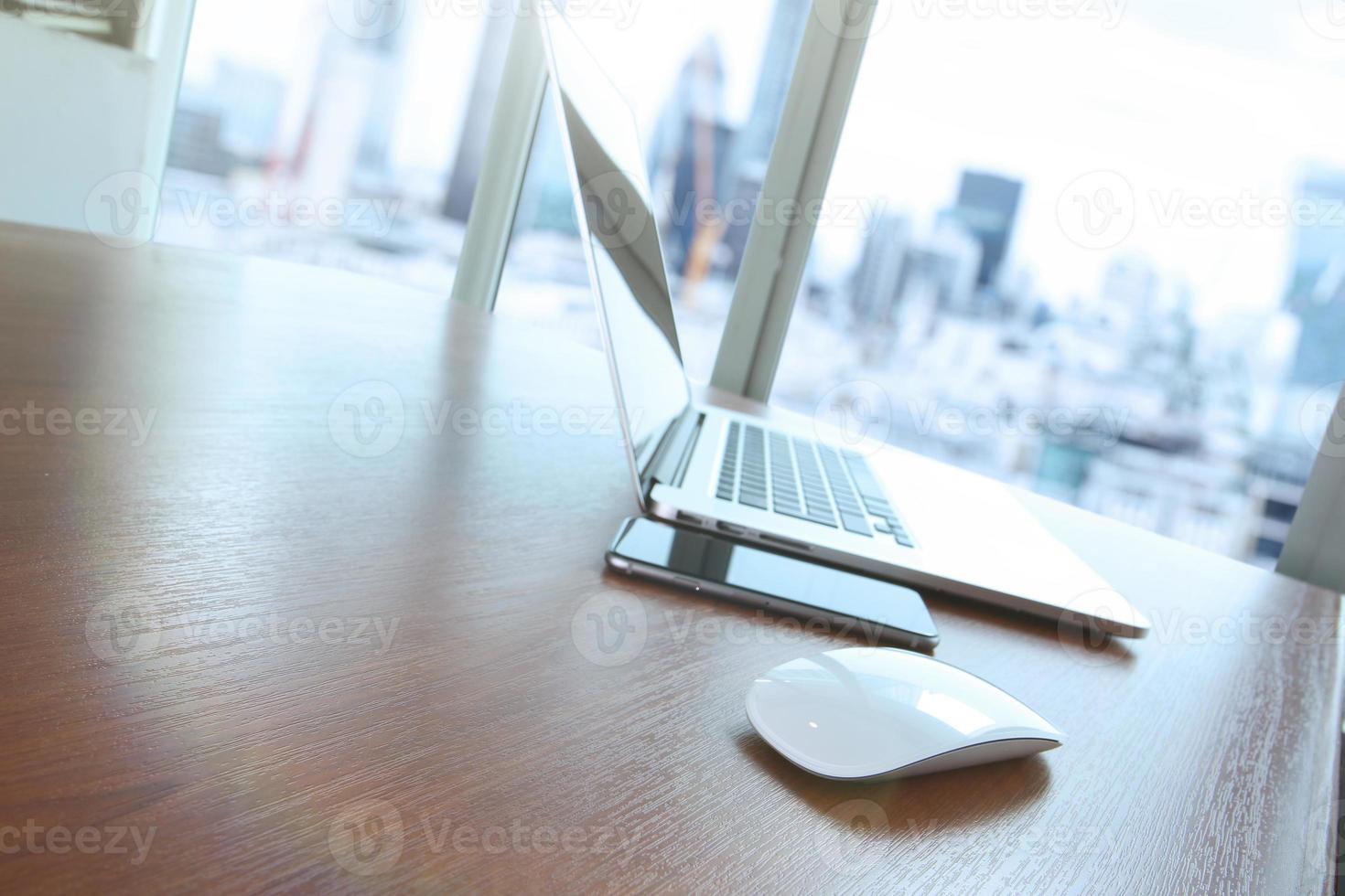 mouse e laptop está na mesa de madeira como conceito de local de trabalho com efeito nublado foto