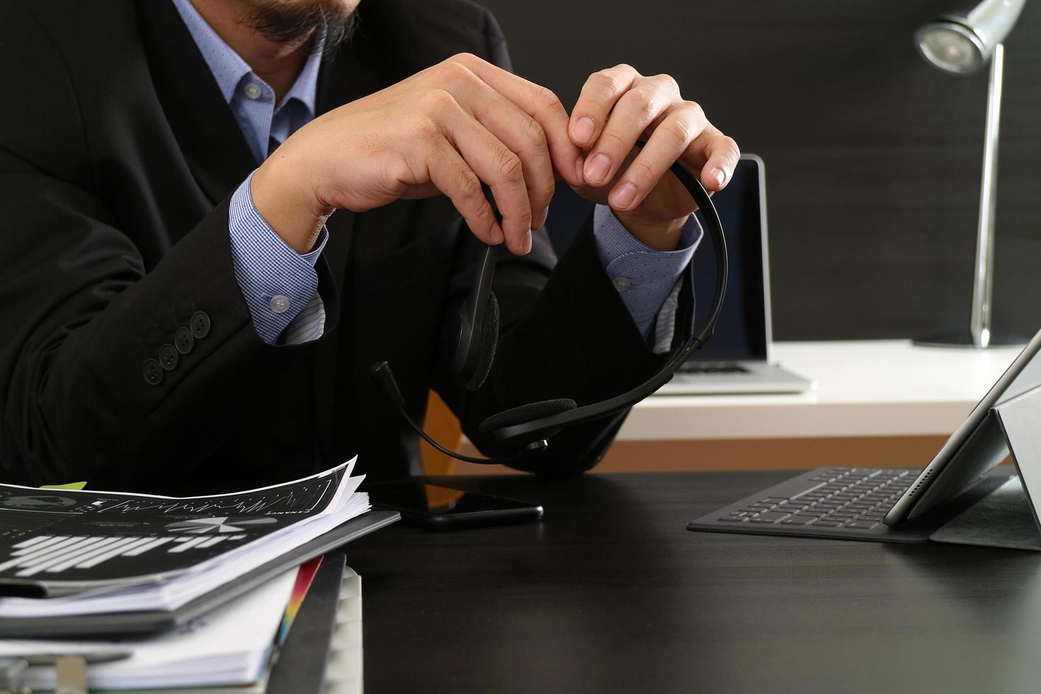 homem usando fone de ouvido voip com computador tablet digital como comunicação de conceito ou suporte ou call center e atendimento ao cliente no escritório moderno foto