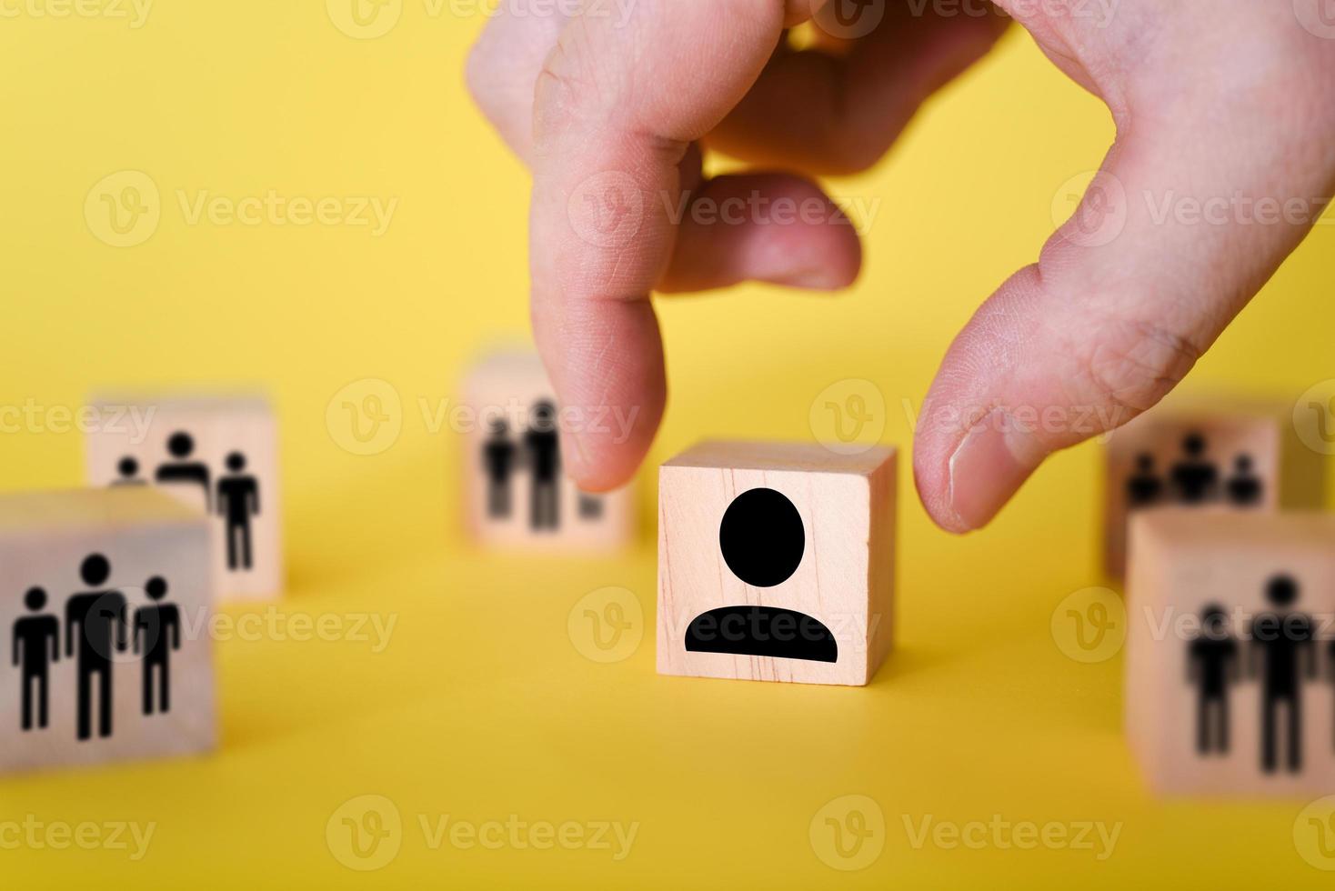 a busca por novos gestores para liderar organizações e equipes é mostrada por meio de cubos de madeira, em fundo amarelo. foto