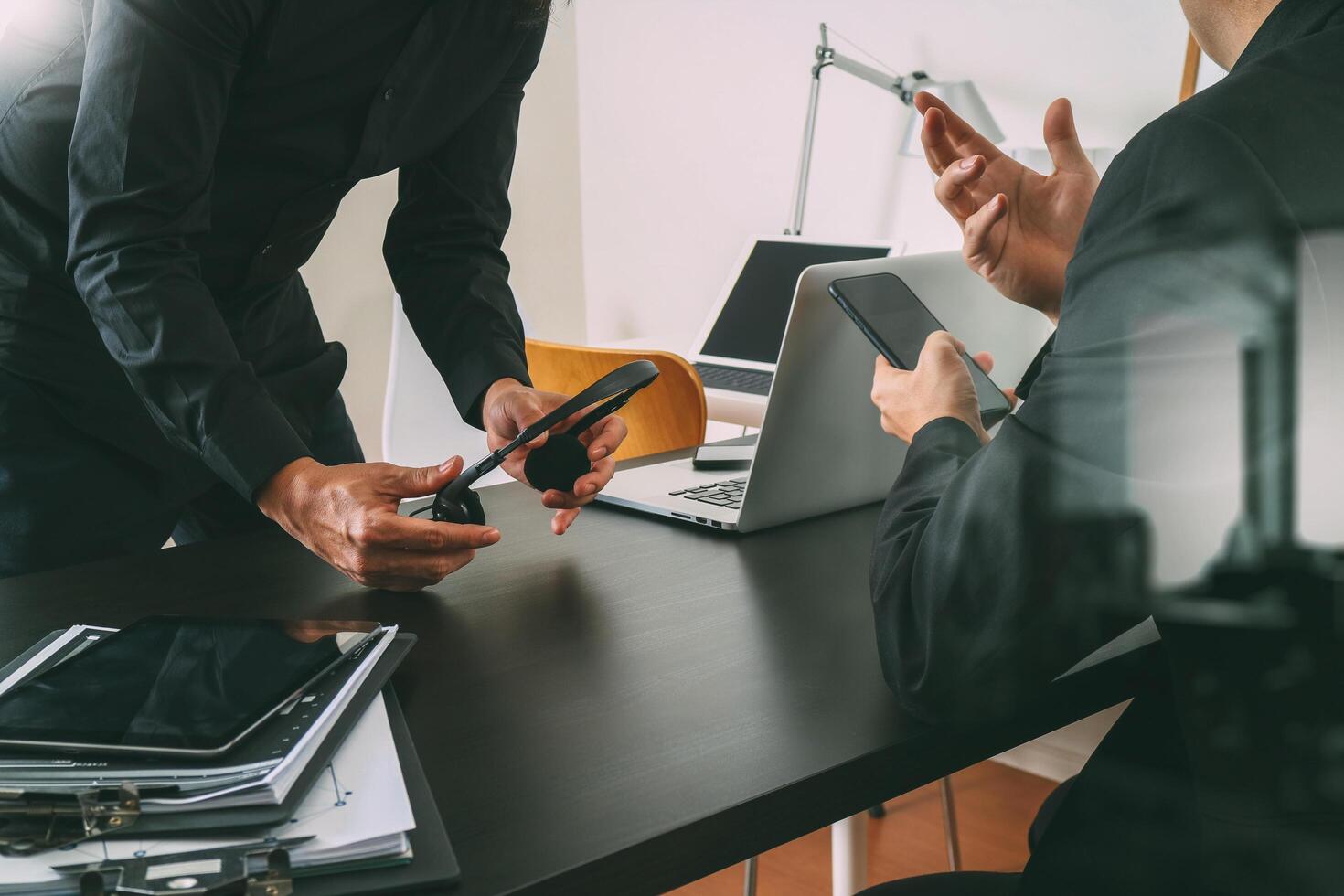 co reunião de trabalho, dois empresários usando fone de ouvido voip com computador latop na mesa no escritório moderno como call center e conceito de help desk de atendimento ao cliente foto