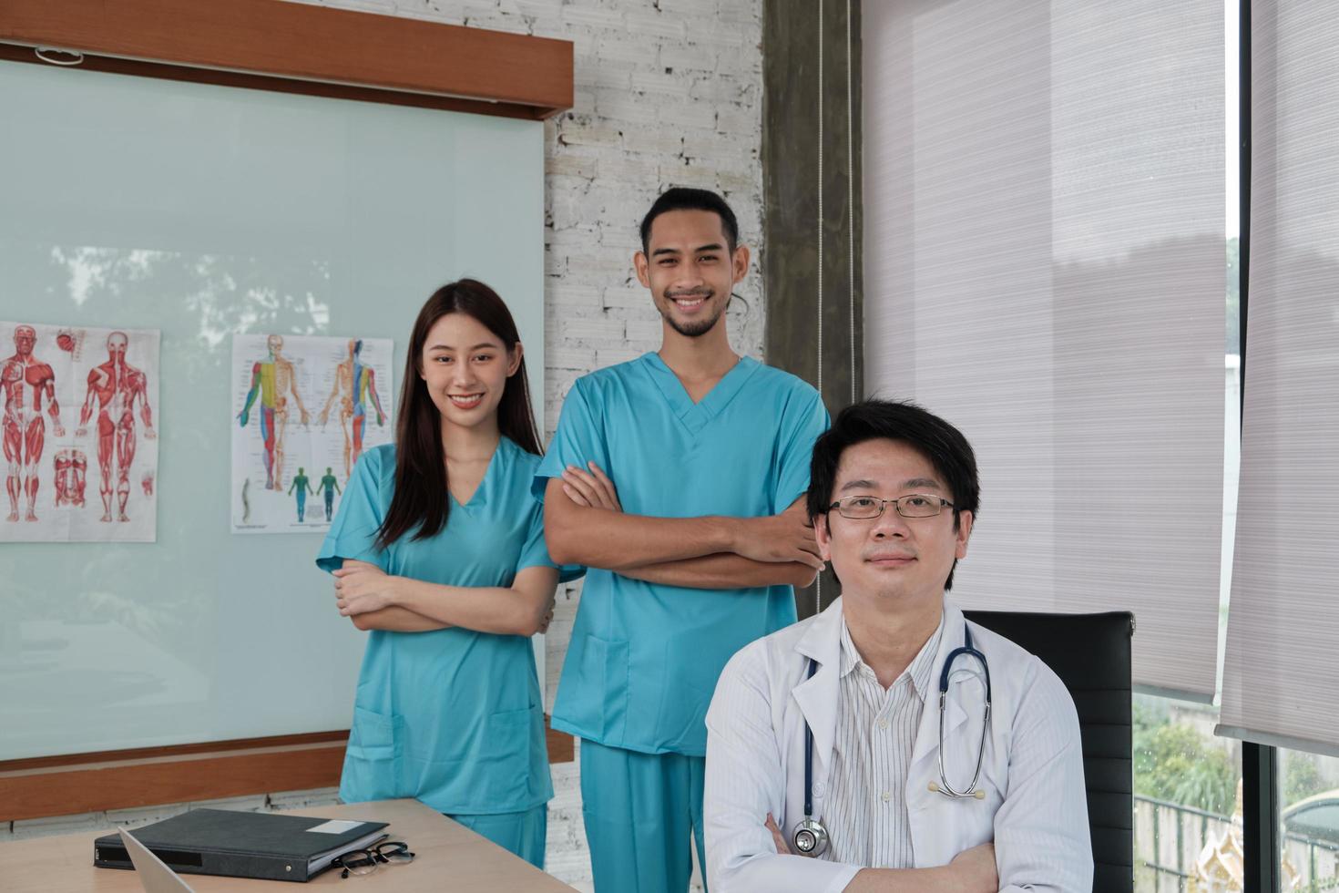 equipe de confiança de saúde, retrato de três jovens médicos de etnia asiática de uniforme com estetoscópio, sorrindo e olhando para a câmera na clínica, pessoas com experiência em tratamento profissional. foto