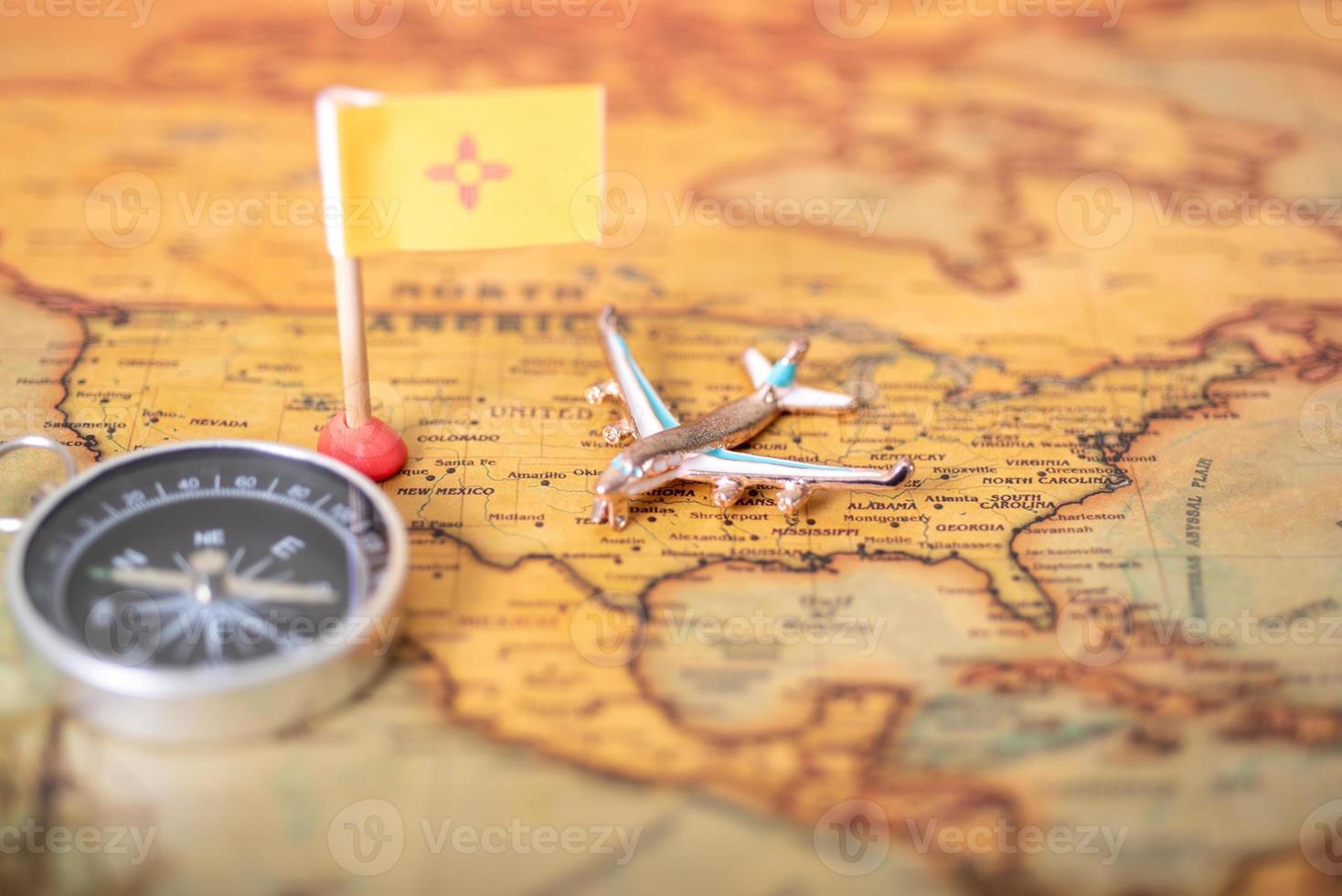 a bandeira do novo méxico, o avião e a bússola do mapa do velho mundo. foto