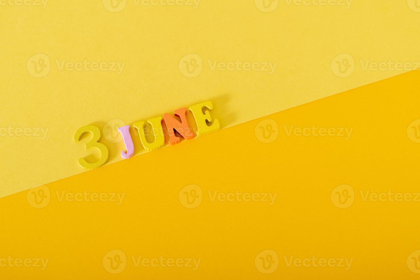 3 de junho. 3º dia do mês, data do calendário. letras e números de madeira em um fundo amarelo, dia mundial da bicicleta. foto