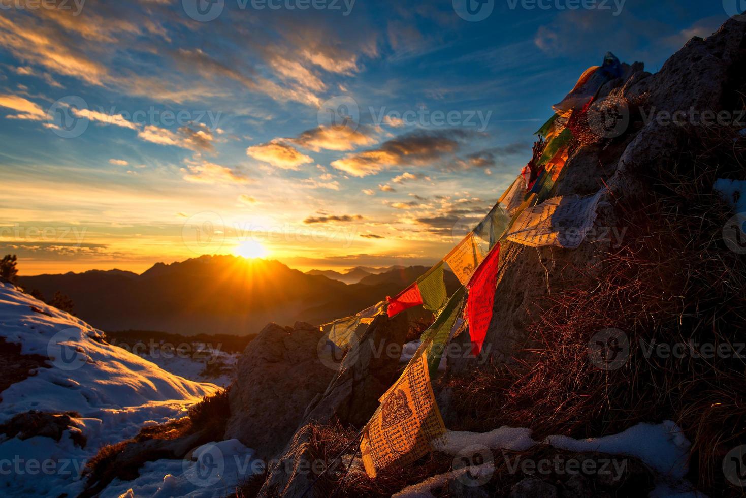 bandeiras de orações tibetanas nas montanhas com as cores de um pôr do sol quente foto