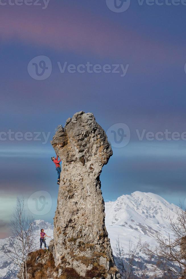 pico rochoso com alguns alpinistas em cordas foto