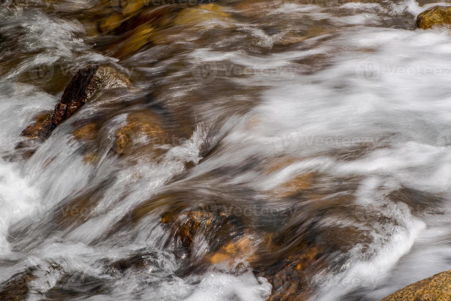 fluxo de um rio de montanha com pedras arredondadas foto