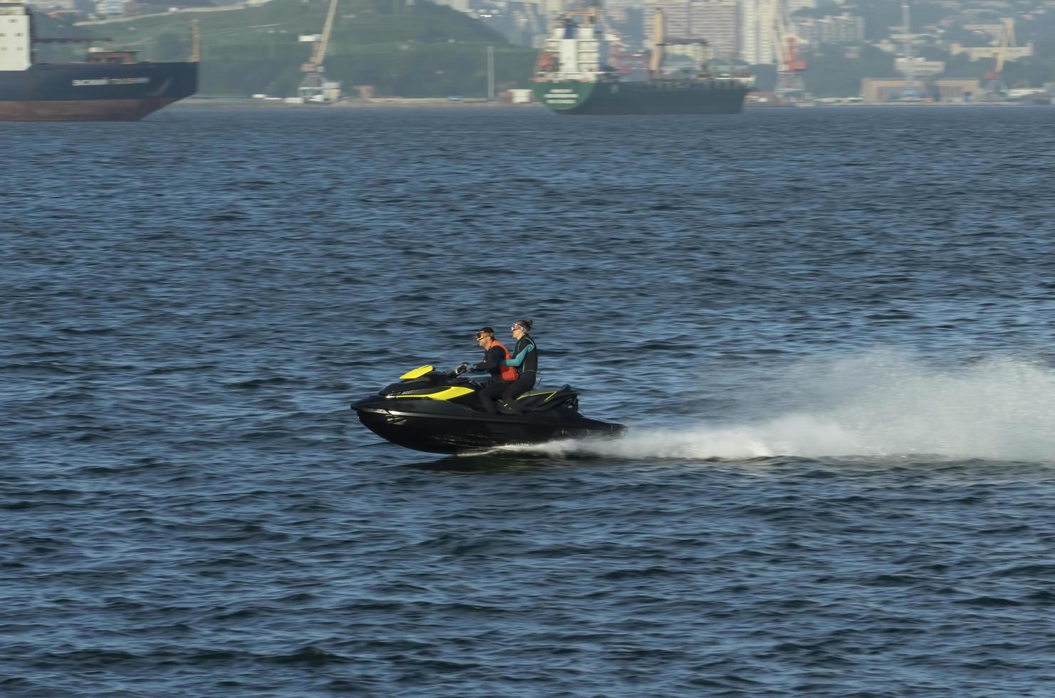 vladivostok, primorsky krai - 26 de agosto de 2018 - um homem e uma mulher andam no mar em uma hidro scooter. foto