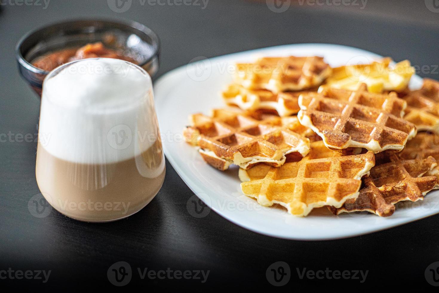 excelente café da manhã waffles belgas vienenses geléia de maçã e uma caneca de cappuccino quente foto