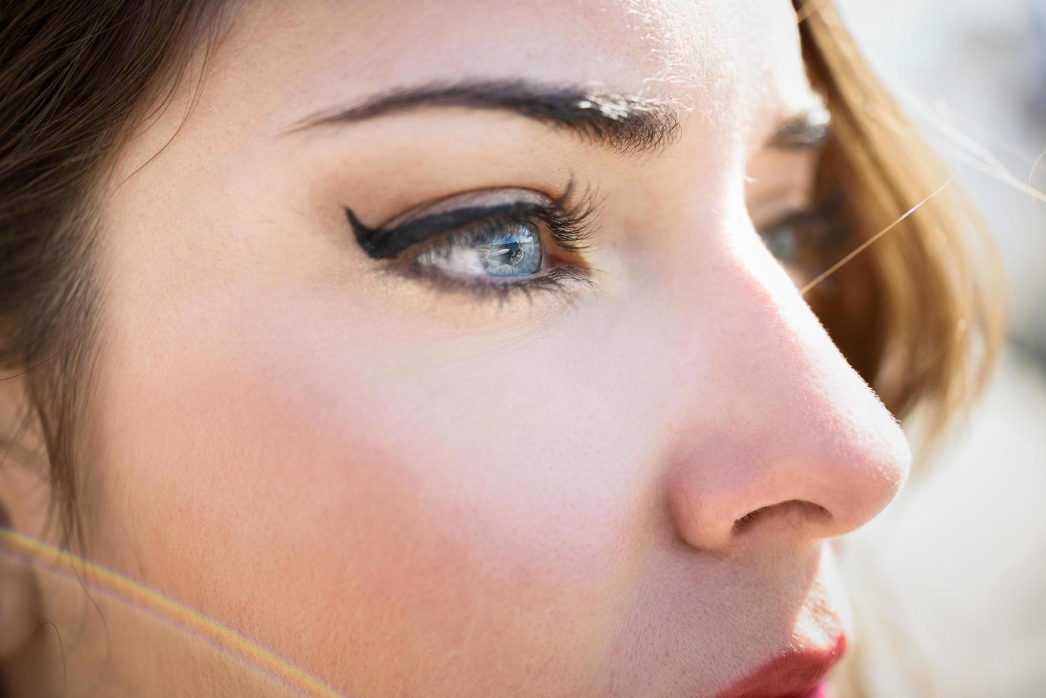 close-up dos olhos azuis da jovem com cílios longos foto