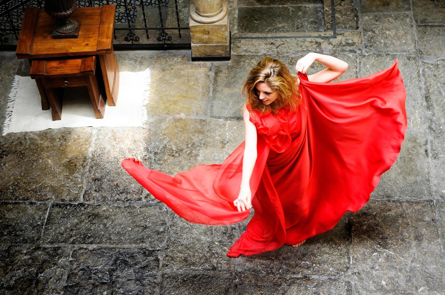 linda mulher loira, vestindo um vestido vermelho, pulando foto