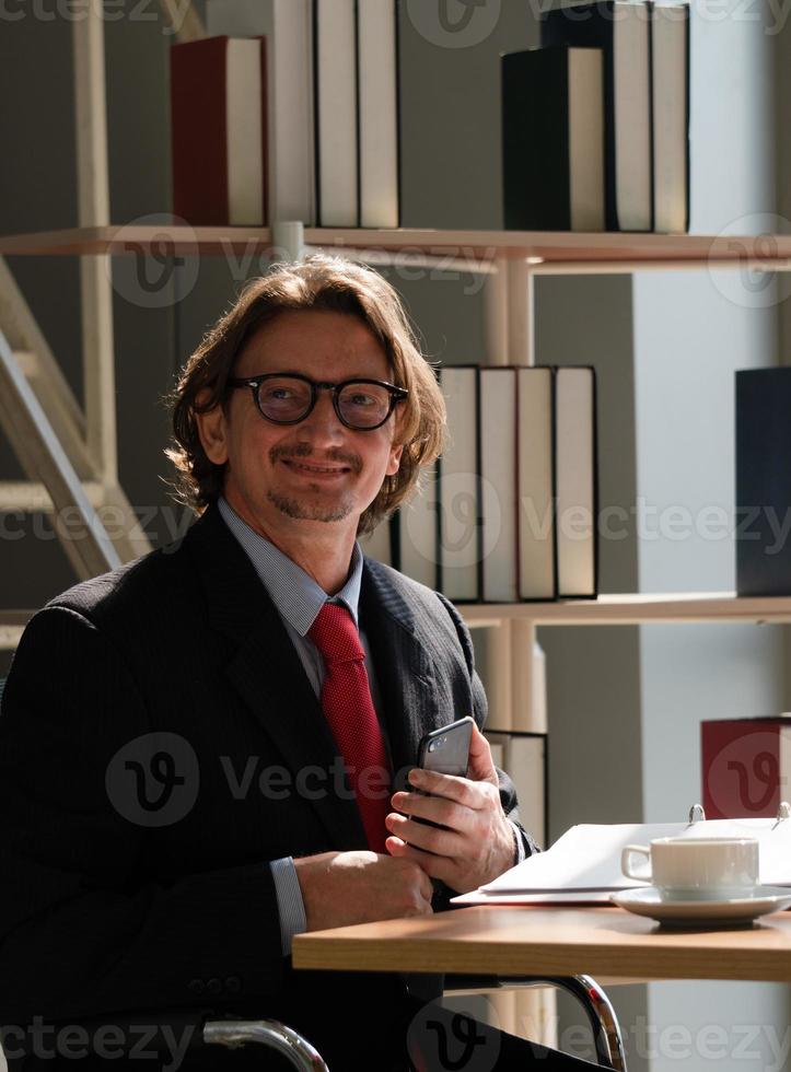 retrato do empresário de meia idade vestindo terno trabalhando no escritório foto