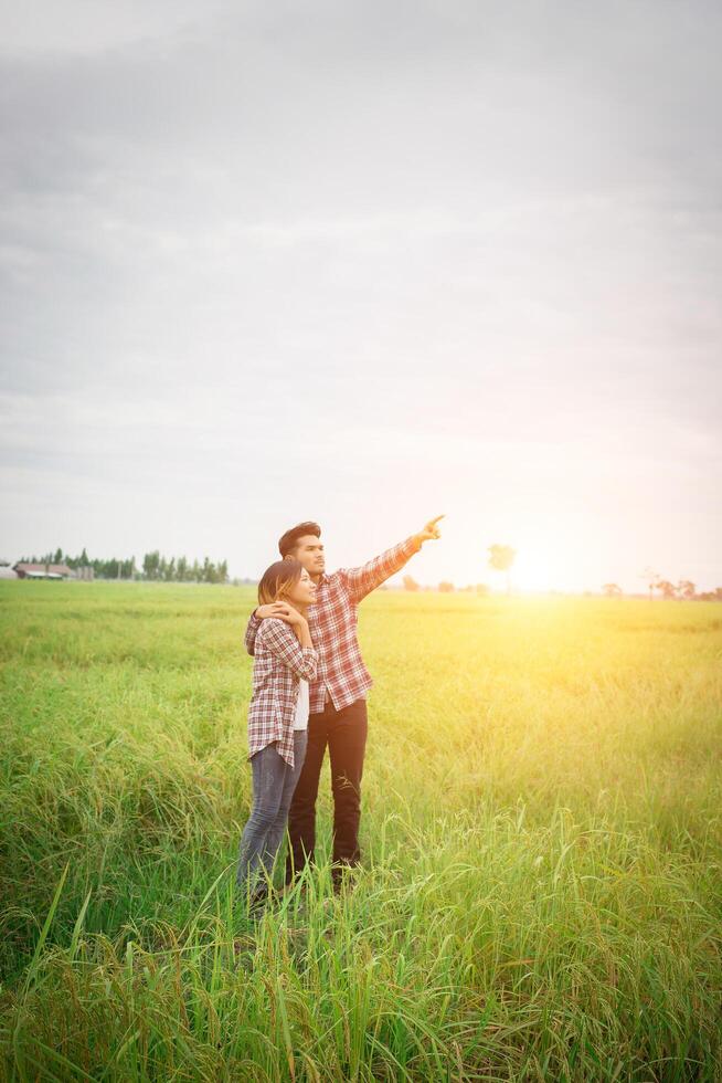 casal jovem hippie dançando no campo apontando o olhar para o céu, casal apaixonado. foto