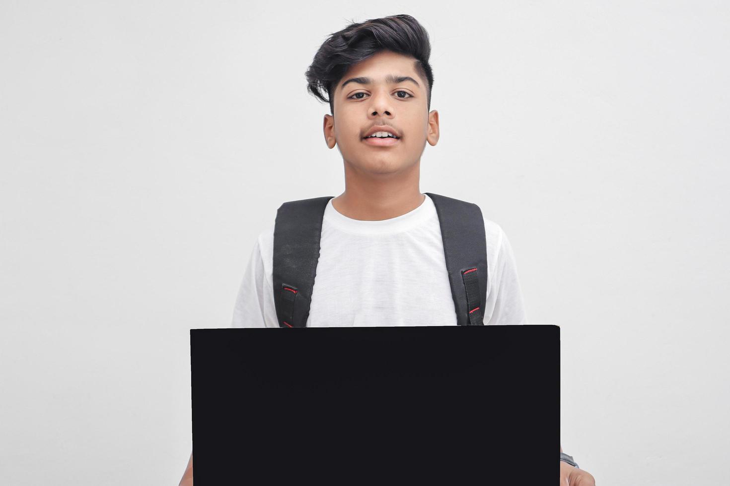 estudante universitário indiano apresentando placa em fundo branco. foto