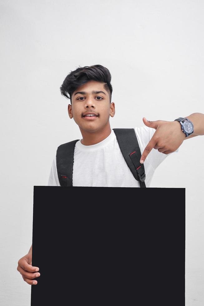 estudante universitário indiano apresentando placa em fundo branco. foto