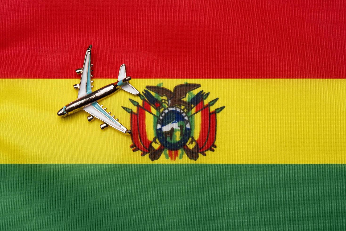 avião sobre a bandeira da bolívia o conceito de viagens e turismo. foto