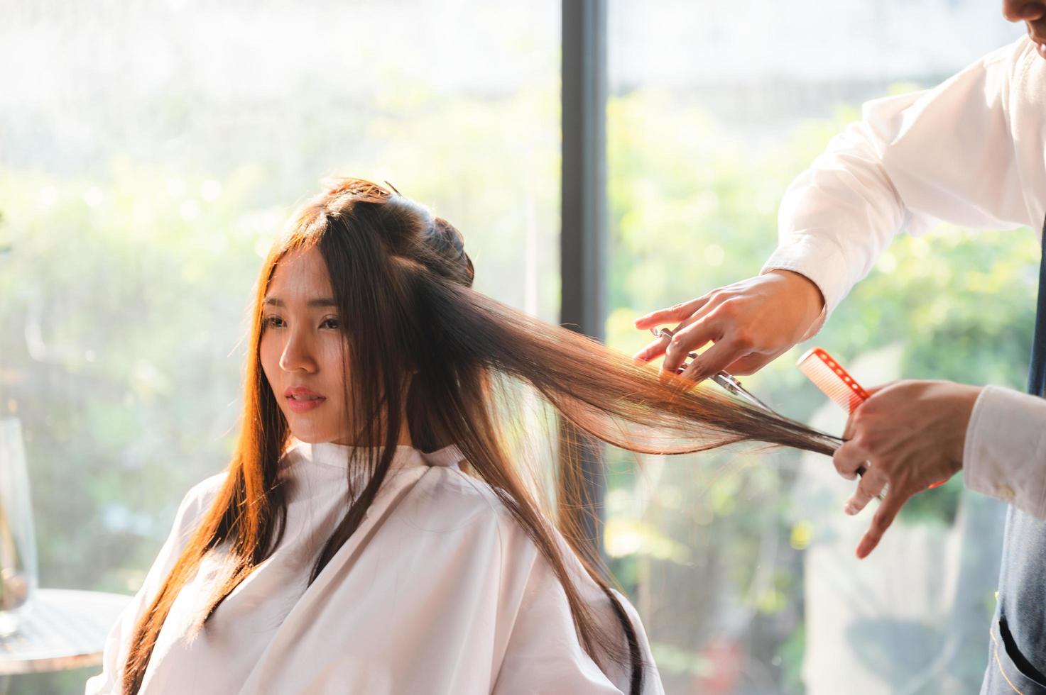 cabeleireira e linda cliente mulher fazendo tratamento cuidados de saúde capilar em salão de estilo de moda foto