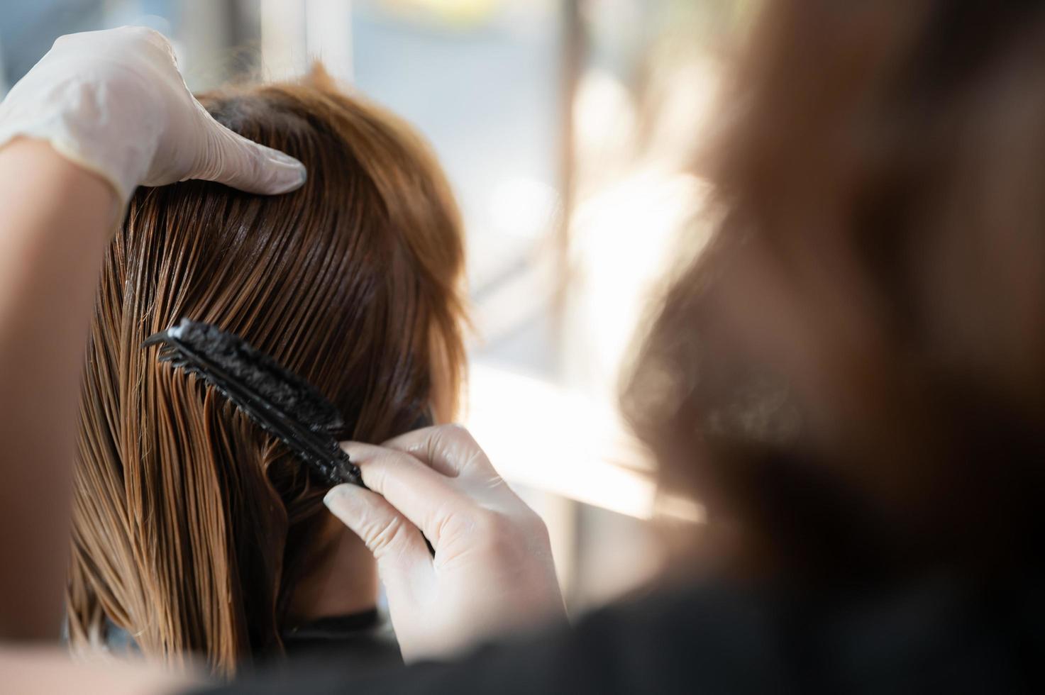 mulher cliente pessoa tendo um processo para fazer tratamento de cabelo com cabeleireiro no salão de beleza foto